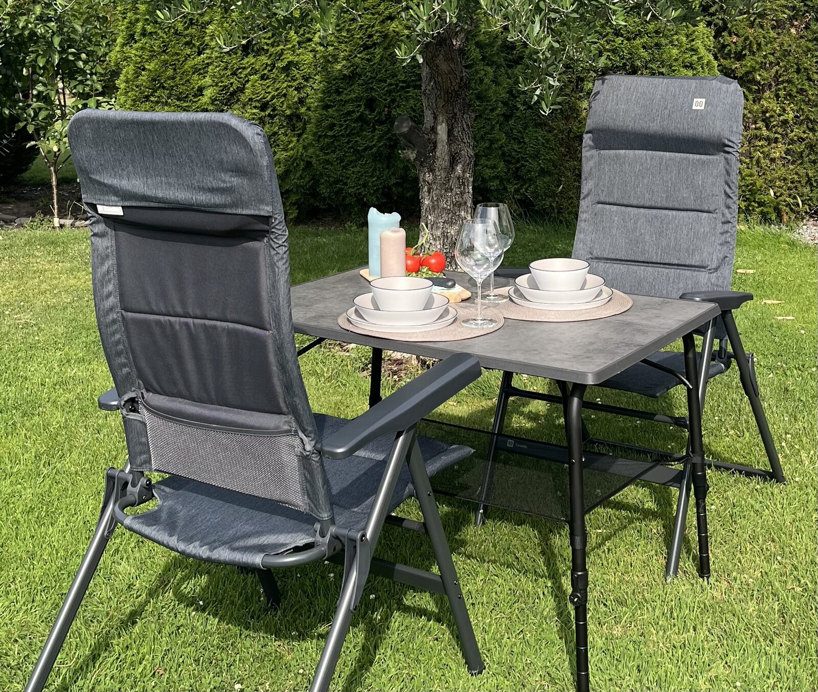 Campingtisch mit zwei Campingstühlen im Garten